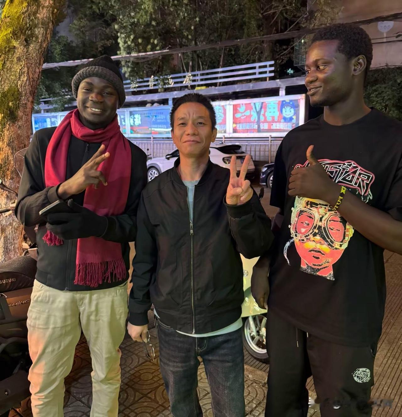 大叔刚到广州，在街上碰到两位黑人朋友，很是激动，急忙要求旁边的路人帮忙拍照，与二