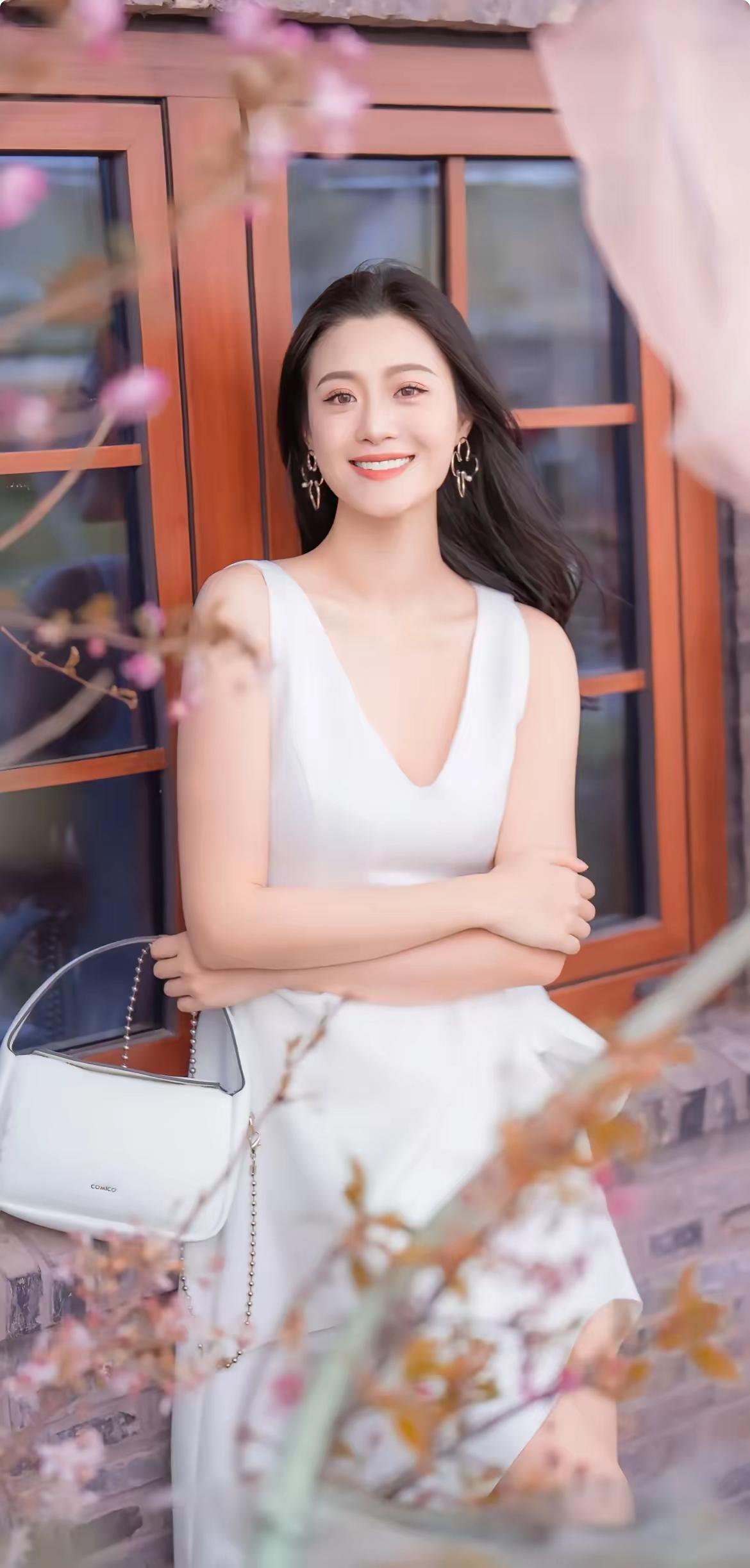 优雅白裙少女，微笑面对生活，手提包点缀，花枝掩映，尽显清新自然美。