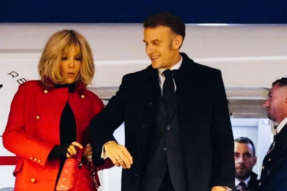 马克龙和妻子配合不够默契啊！马克龙提前把胳膊都抬起来，做好架势了！妻子还在低