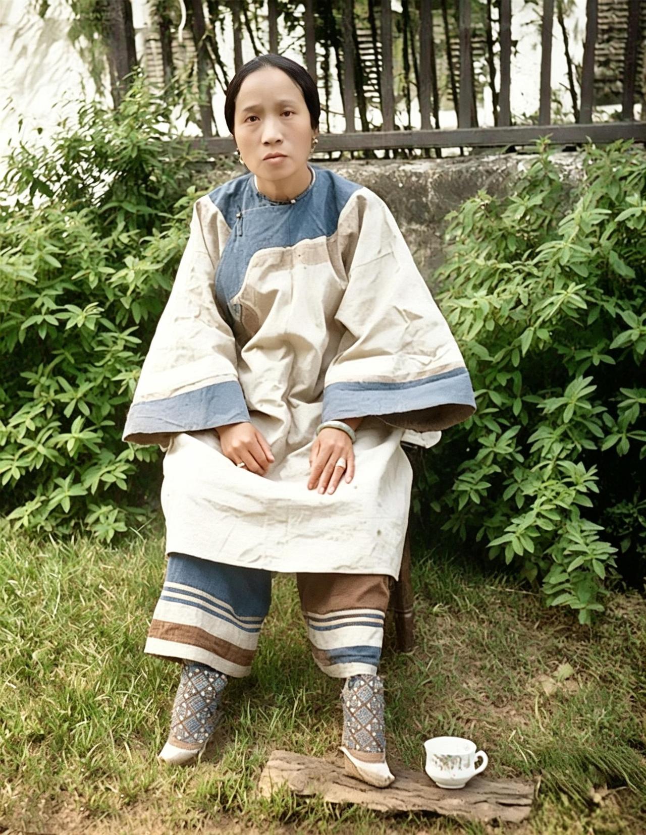 这是百年前的一位妇人，端坐竹椅，面容沧桑得像半百老妣。其实她才三十出头，可那年月