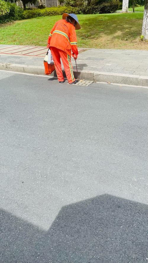 今天在路边等车，一个环卫工阿姨扫到我旁边，停下歇了会儿。她扶着扫把，突然冲我