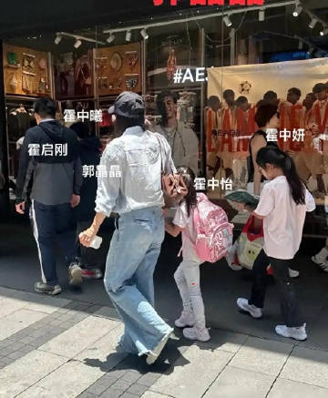 霍启刚一家五口现身街头，郭晶晶手牵小女儿，大女儿边走路边阅读，霍中曦和...