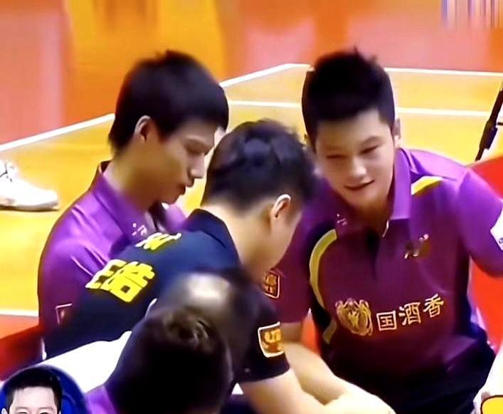 樊振东当众伸手摸王皓的头，就为一坨发蜡。王皓正坐着，小胖一个箭步就凑上去，