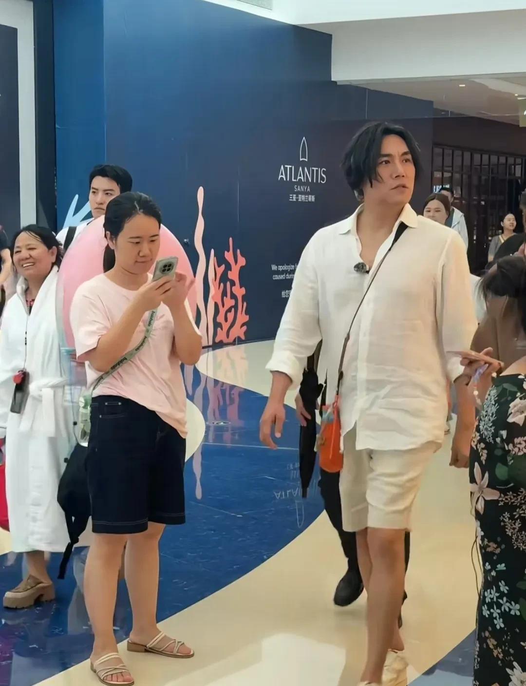 秦昊现身海南三亚，感觉本人经不起镜头，现实的形象有点虐！他穿着棉麻料衬衫短裤，