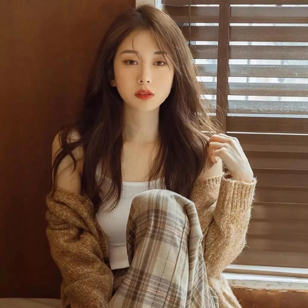 慵懒的午后，温柔的阳光洒进房间，少女慵懒地坐在窗边，微风轻拂她的长发。