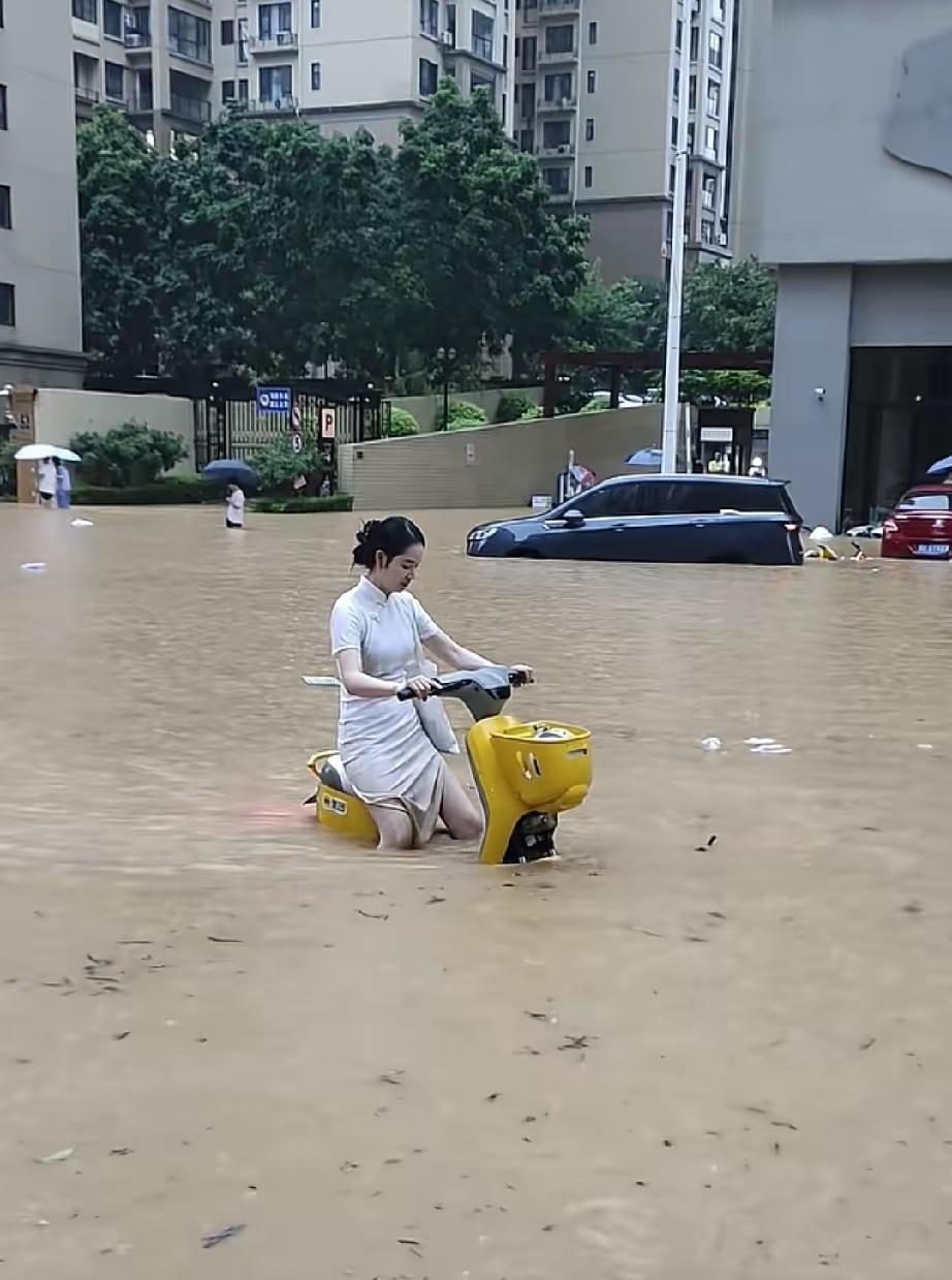 广西又开始新一轮暴雨，大街一片汪洋，竟然有小姐姐骑着电瓶车飞驰在大街上，看着让人