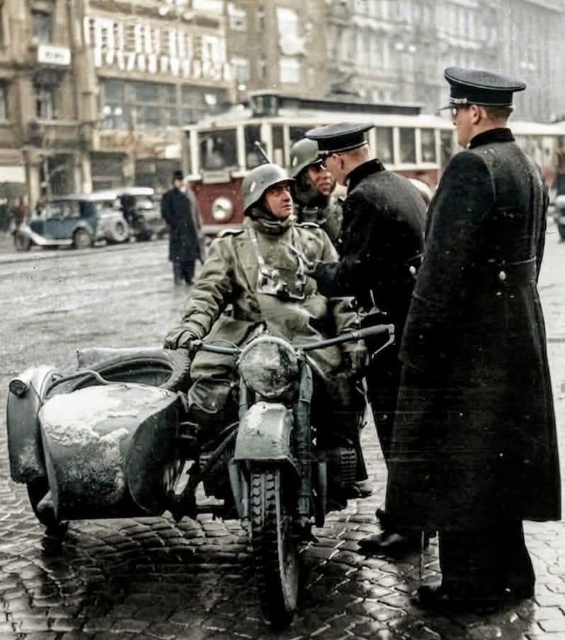 1939年，德国吞并捷克斯洛伐克后，布拉格街头，捷克警察正与德军摩托化部队士兵攀