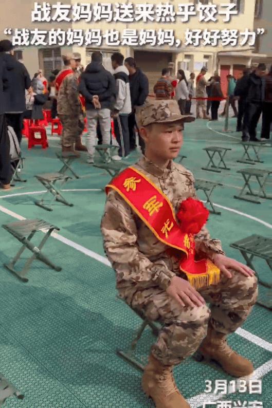 广西兴安，小伙子被召入伍，父母都在外地打工不能来送行，小伙子孤单地坐在小马扎上，