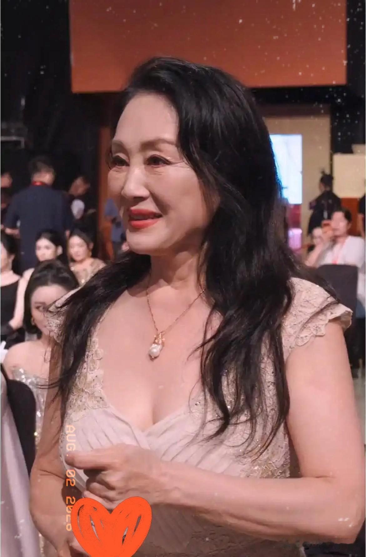 金鸡奖红毯上，64岁的王姬穿了条黑色亮面鱼尾裙，因为侧边开叉，结果肚子上一道