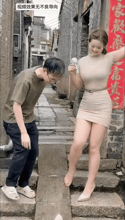 漂亮的女人，高跟鞋掉了，她看到一个男人从她身边路过，女人拍了拍男人的肩膀，告诉男