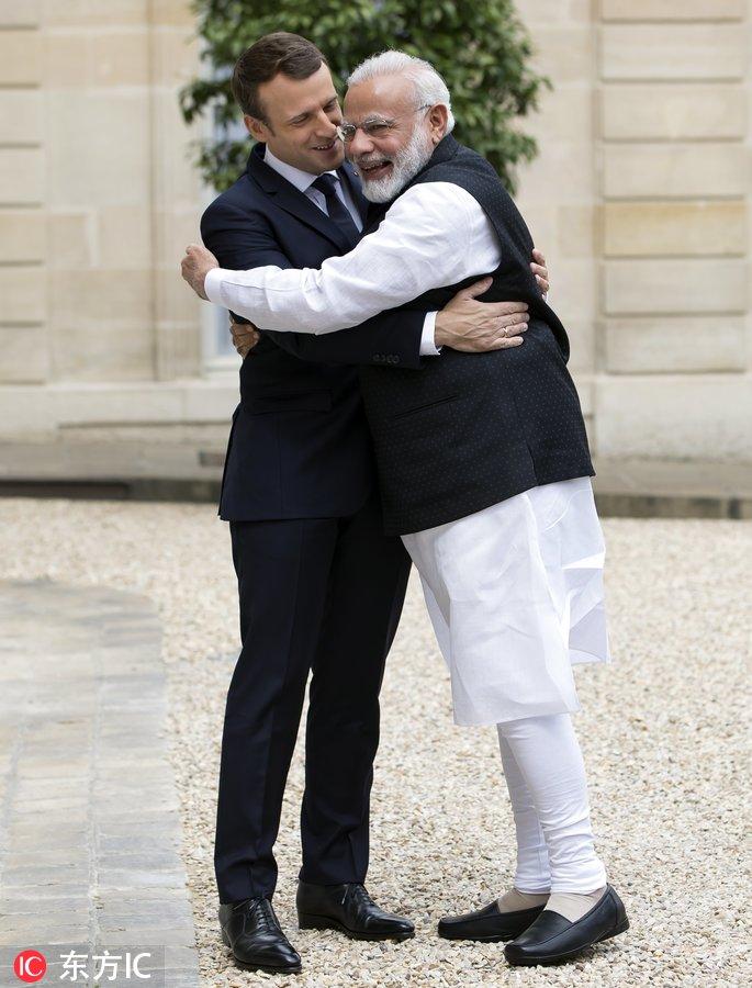 莫迪和马克龙手拉手，拥抱的两人看起来是忘年交呀。马克龙的妻子和莫迪手指相扣笑得很