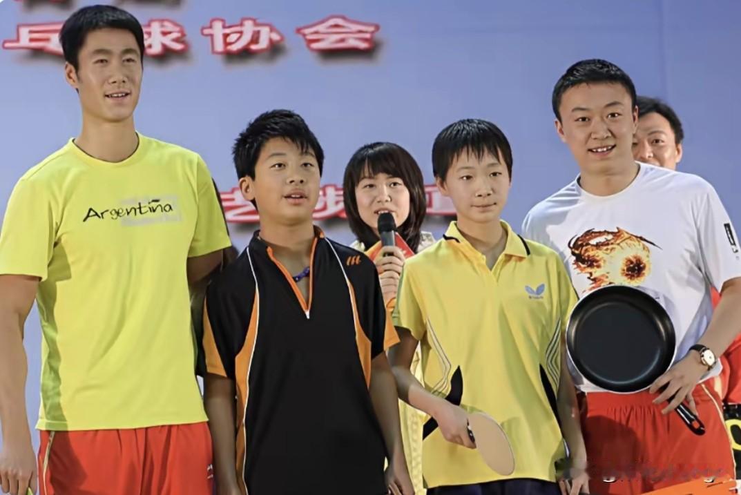 这张照片定格了国乒两代人之间最纯粹的传承瞬间。画面中，初出茅庐、略显青涩的王