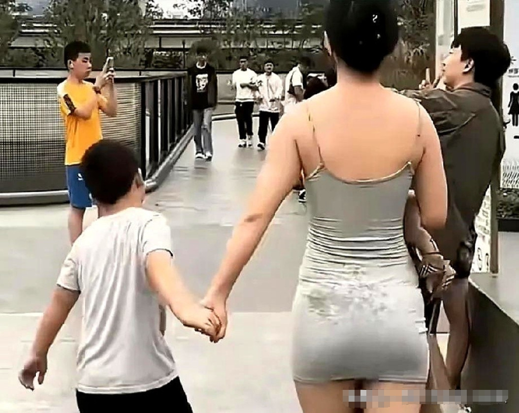 安徽合肥，有一位阿姨出门买菜，看到有一名女子牵着儿子外出，女子穿着灰色的吊带包臀