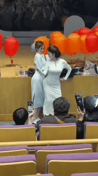 两个女子扭捏作态，搔首弄姿，自以为跳的很美，其实真是丑陋极了。看着好像是个开会