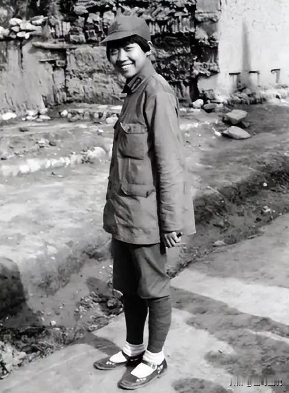这不是剧照，而是真实的红军女战士，照片中的她侧身站着，面对镜头，看上去还有些腼腆