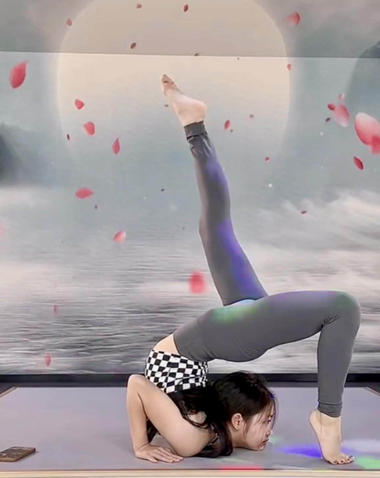 打油诗·瑜伽俏影瑜伽垫上展英姿，高难动作有巧思。花瓣飘落增雅意，柔韧力量