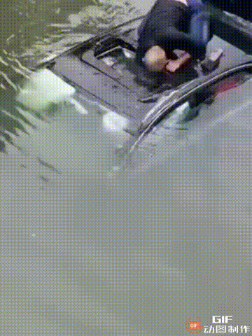一位车主开车时不慎掉入河里，整个人困在车内无法逃出，这时一名光头大哥见状，当即跳