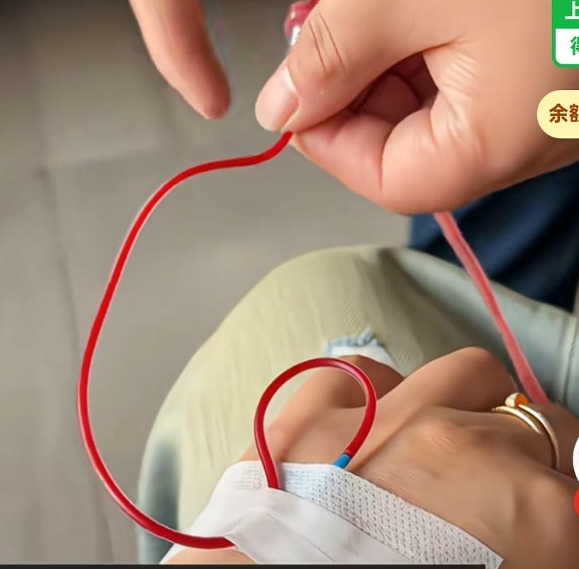 女子到诊所里输液，但是输液管里弄的全是回血，医生在旁边使劲弹管子，想把血弄回