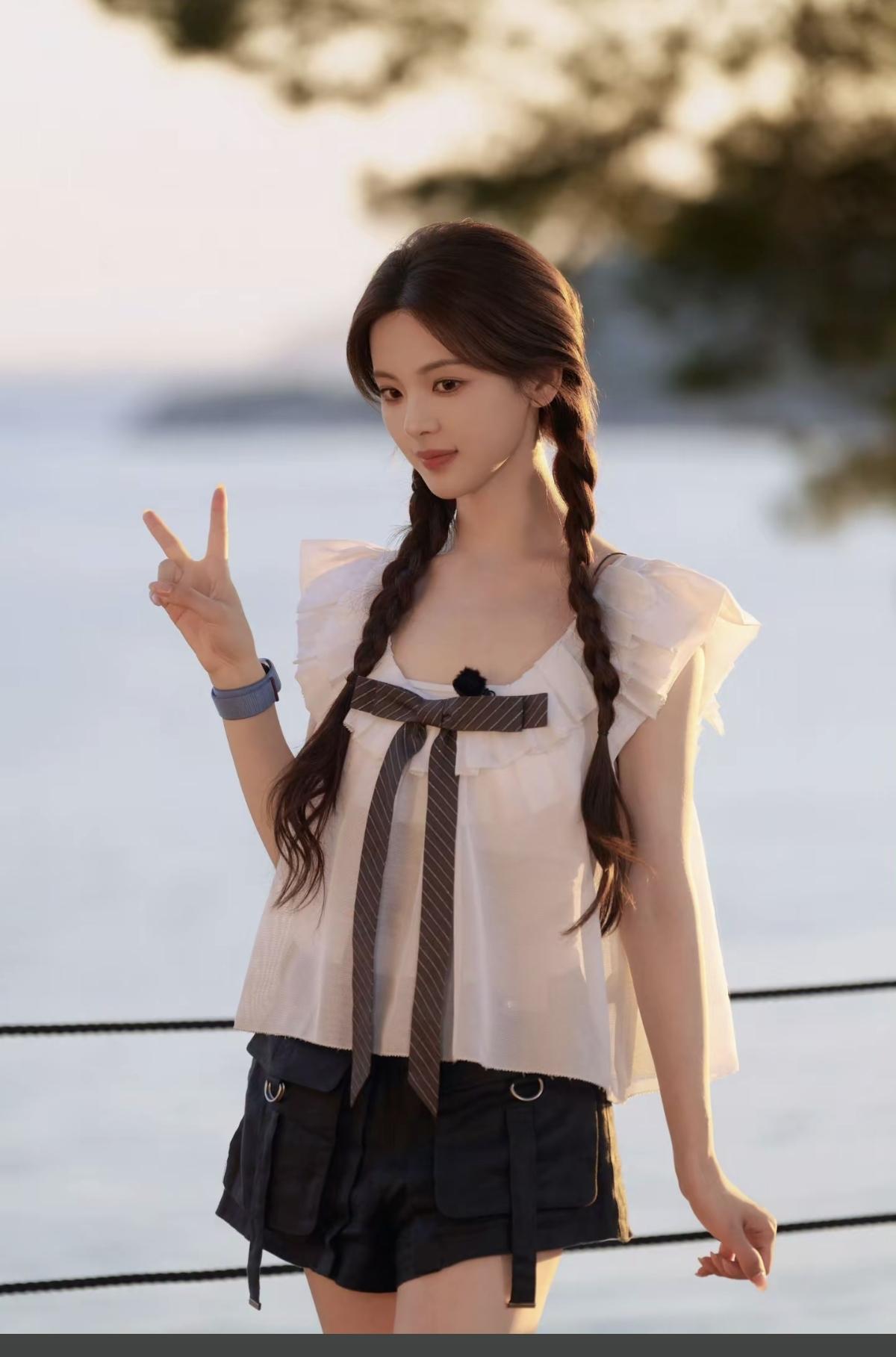 落日漫过海面，杨超越梳着温柔双麻花辫，晚风裹挟着夏日的浪漫，少年感与温柔感撞个满
