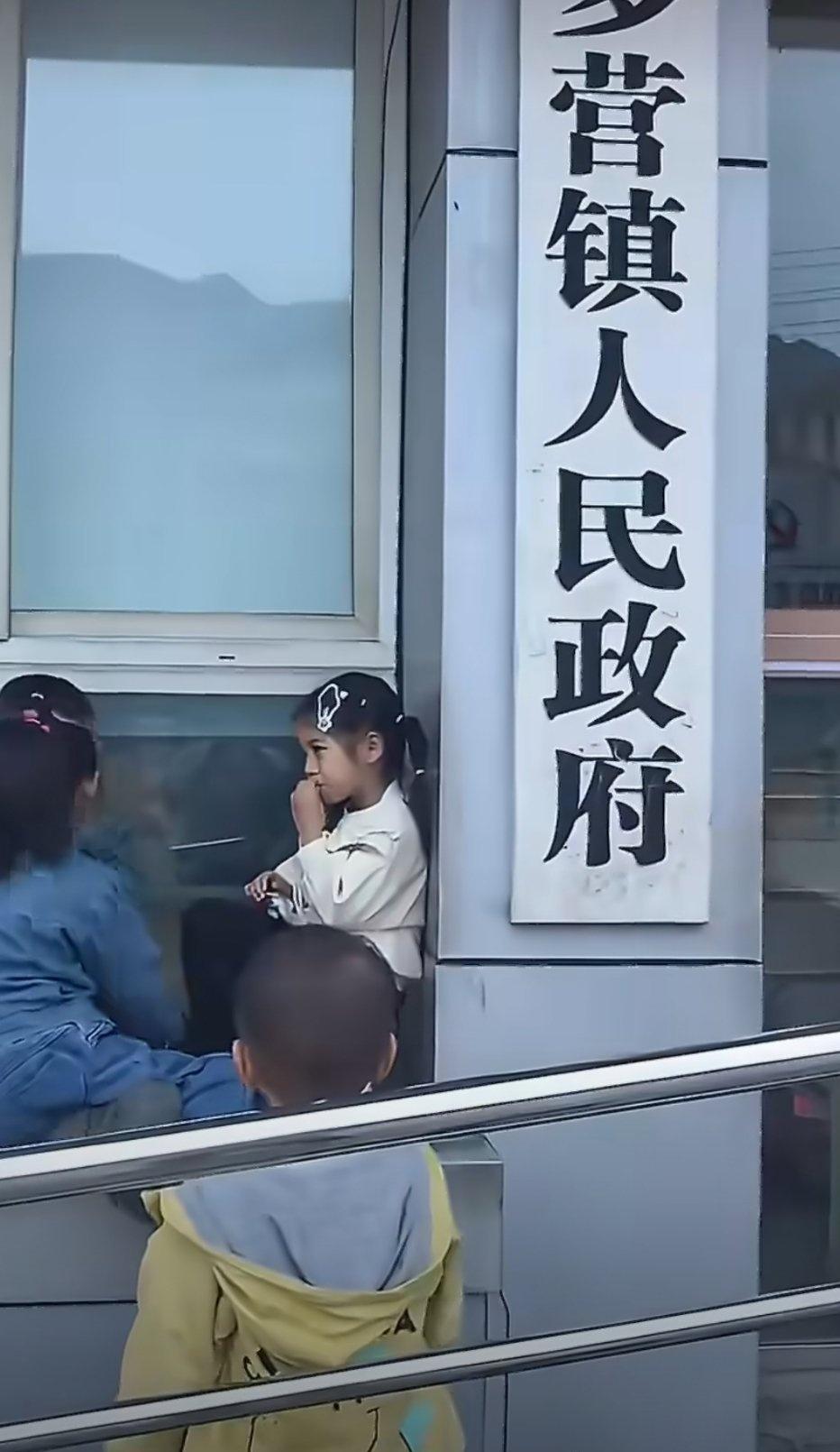这也太治愈了！四川雅安，一群小孩坐在镇政府的门前玩耍，甚至还在两侧的牌匾上面进行