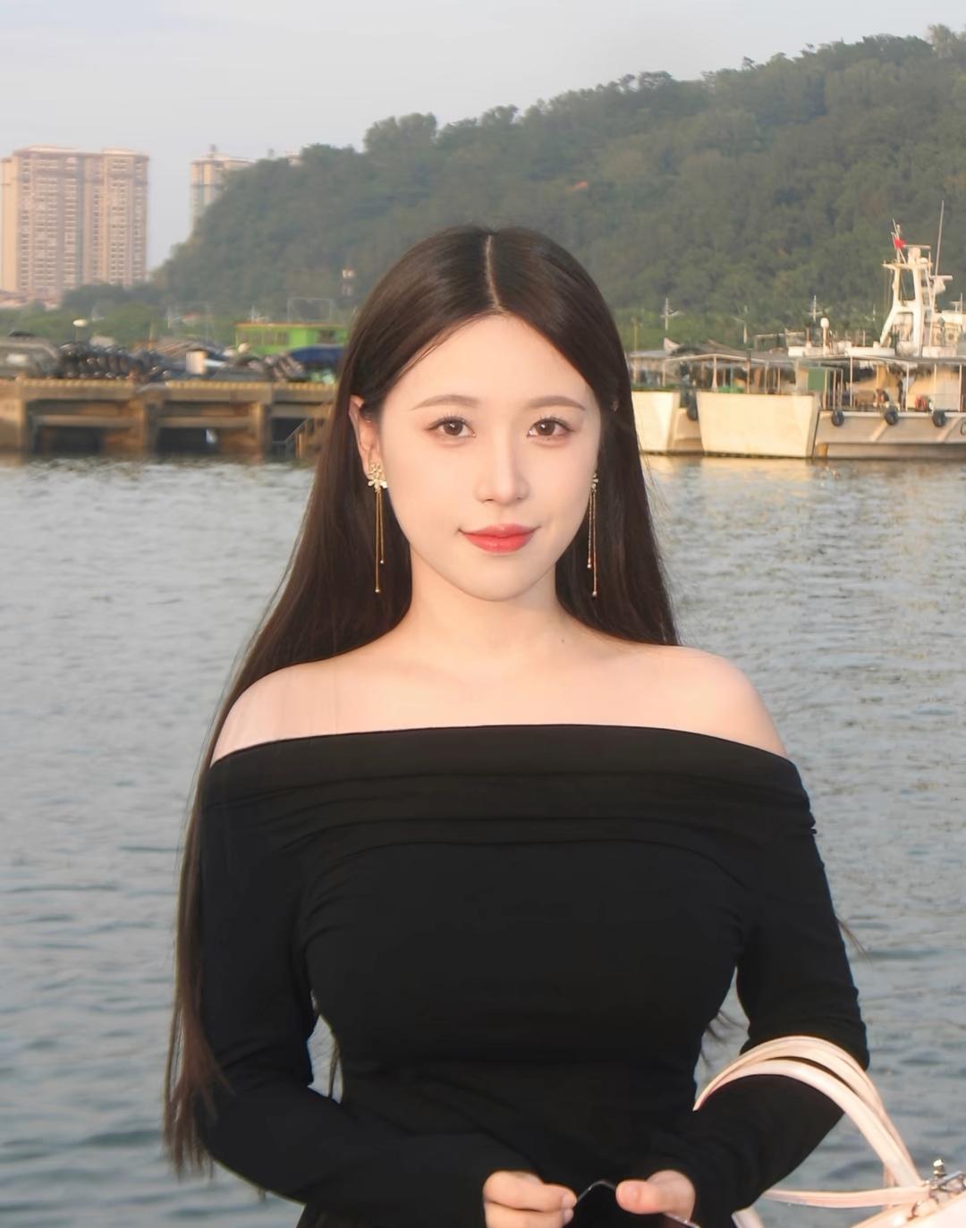 海边漫步，黑裙与海风相得益彰，优雅动人。