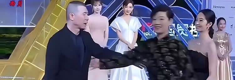 当年在一次活动上冯小刚把手伸出想牵美女杨采钰时被妻子徐帆眼疾手快一把挡了过去冯小