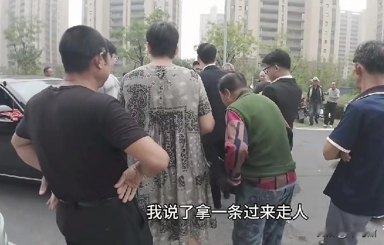 某小区里，又遇到拦婚车要烟的。一穿睡衣的女子带头，喊来小区群众拦着一辆婚车，