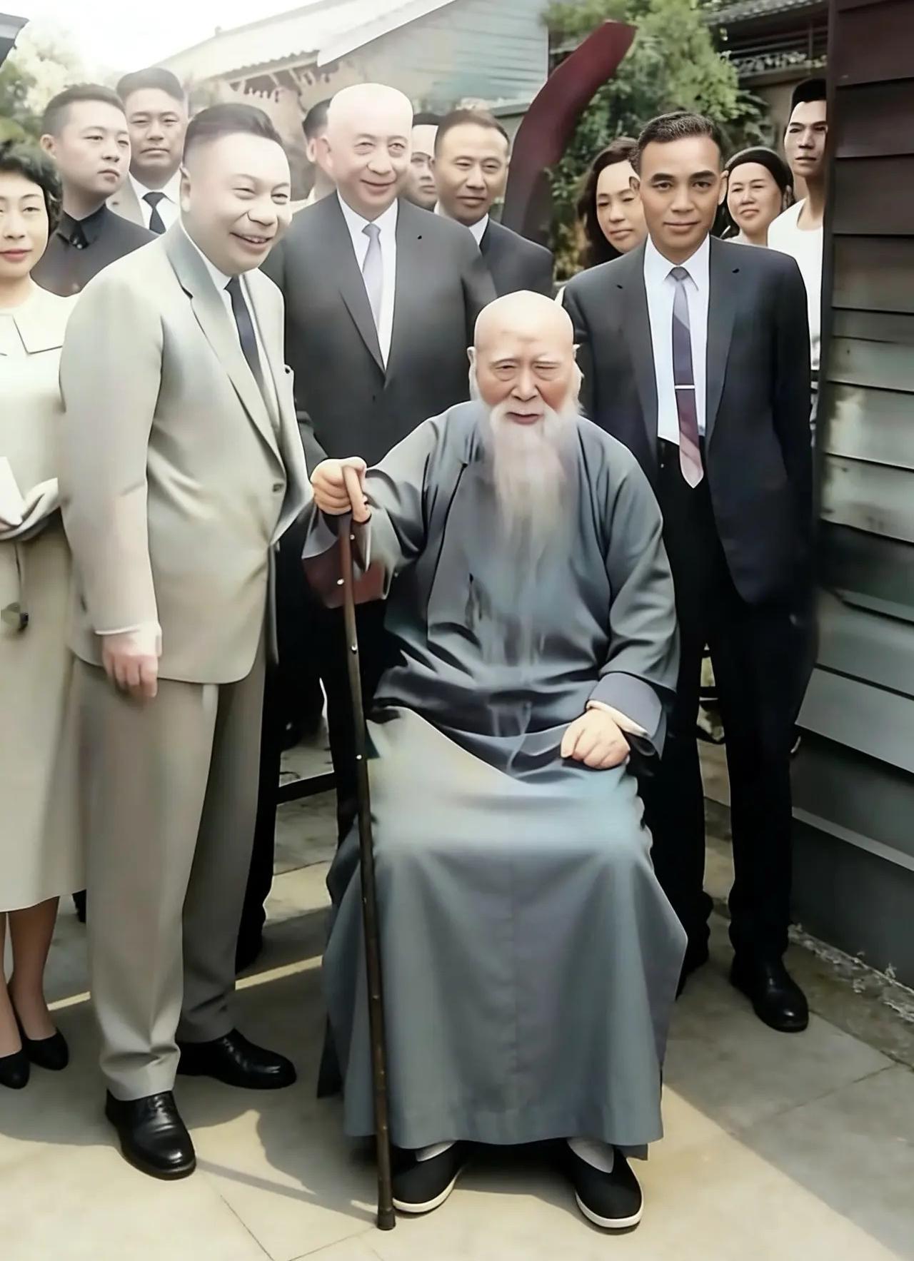 1958年，于右任八十大寿时留下的照片，镜头中他手拄拐杖，穿着青色长袍坐在椅子上