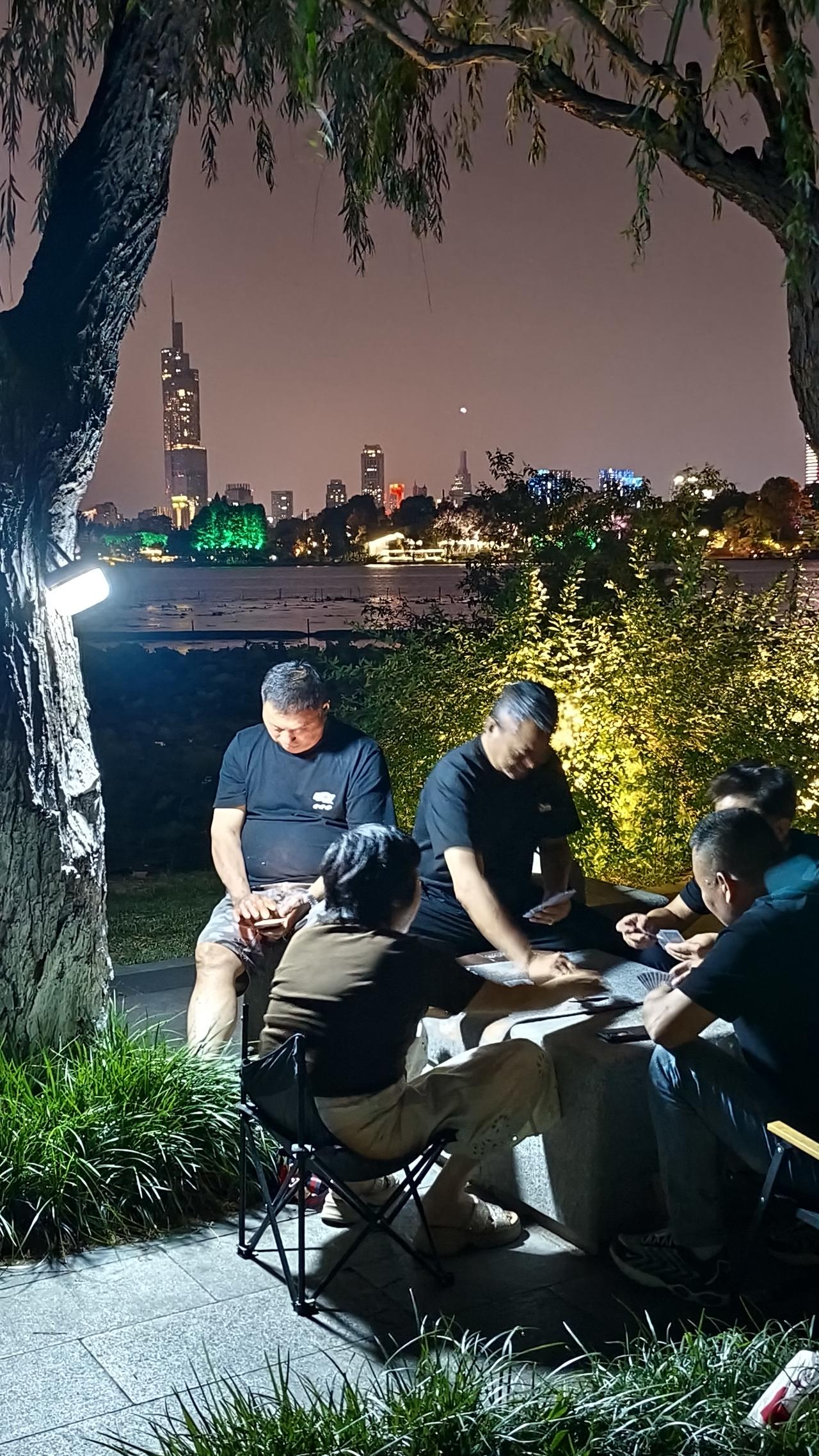 《紫峰大厦为背景，玄武湖夜牌局开始了》南京人的夏夜，一半是玄武湖的晚风