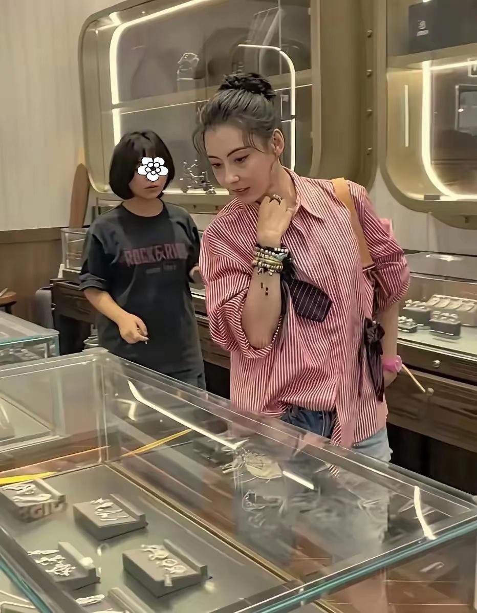 张柏芝现身三亚免税店，专注挑选平价首饰，细致比较尽显认真态度。45岁的她状态依旧