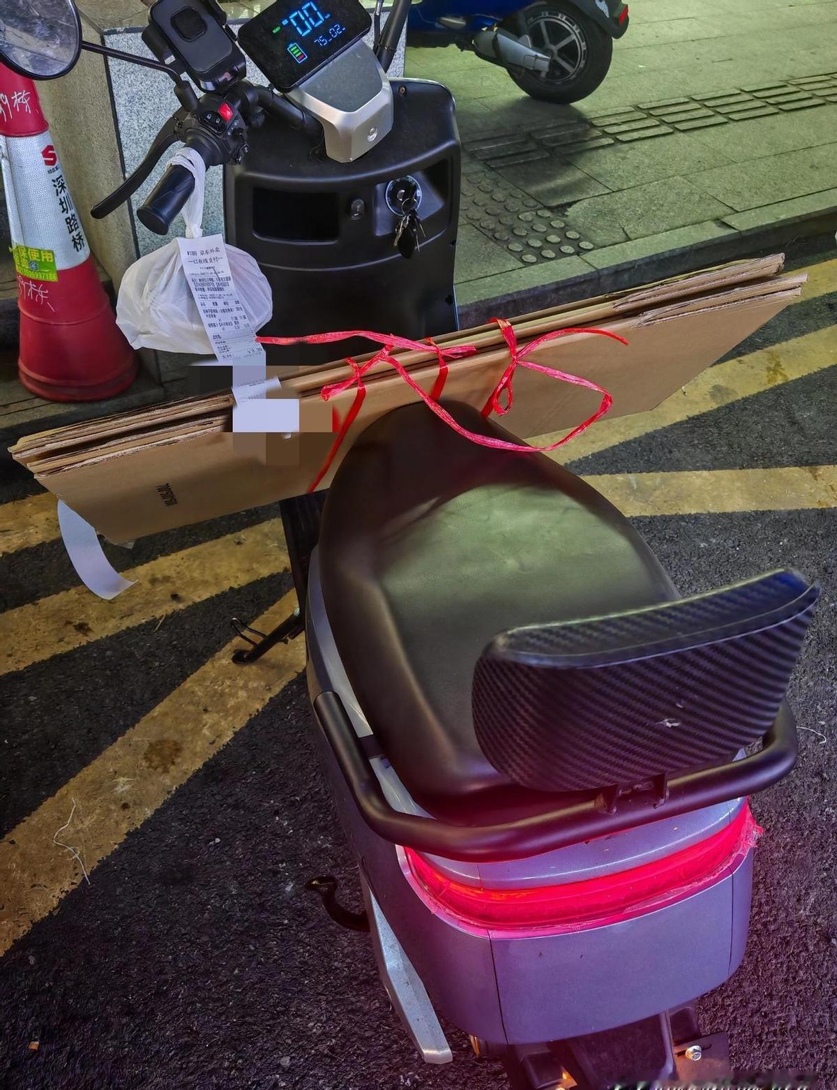 大件纸箱塞电动车上，骑手真不是超人。不敢拒单，怕扣钱；不敢慢走，怕超时。平台