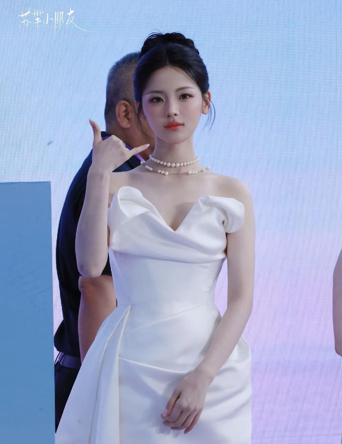 杨超越活动现场，白色缎面抹胸礼服，褶皱立体剪裁，盘发搭配双层珍珠颈链，简约大气，