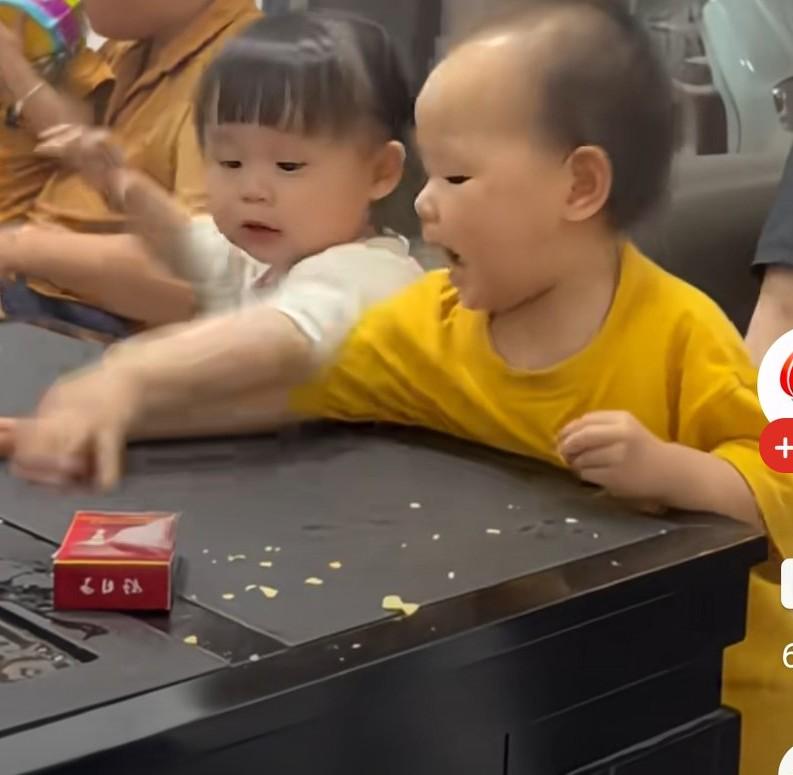 小男孩用身体挤女孩，结果下一秒就被小女孩薅着打，小女孩抓男孩子脸的样子，真的很