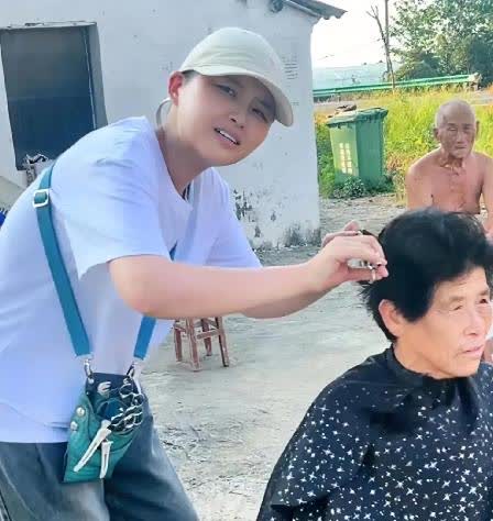 湖北仙桃，路边有个女孩在给老人理发，旁边牌子写着“8元一位，70岁以上老人免费”