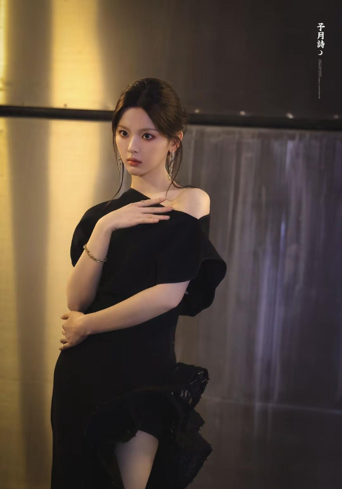 不规则裙摆随姿态轻晃，细碎钻饰在暗处闪着微光，她静立的模样，像夜风中盛放的黑玫瑰