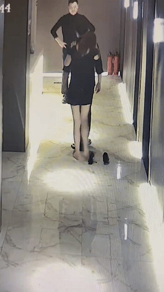 一名年轻女生让她的男朋友背着她一起出门。她为了防止脚上穿的高跟鞋扎到男友，还特