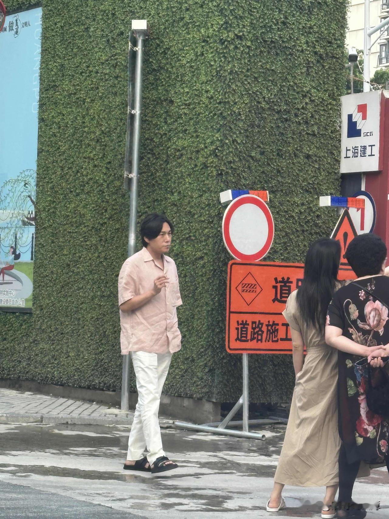 秦昊和伊能静带着公公婆婆出现在上海一处地产的施工处，秦昊穿着拖鞋，梳着中分，手上