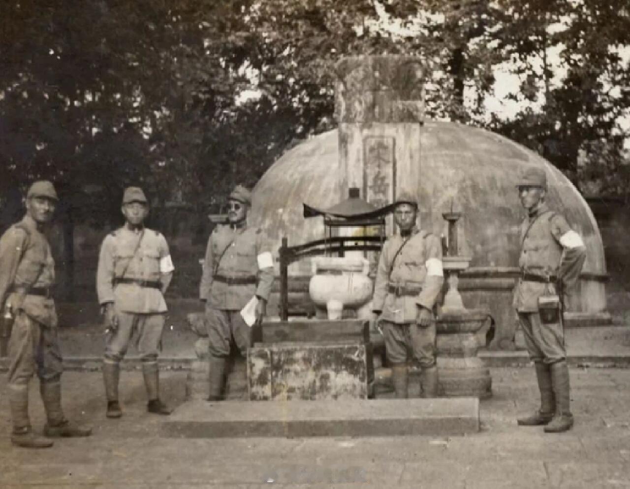 1937年，杭州沦陷后，5个日本兵正站在岳飞墓前的一张老照片。照片中，五名平时残