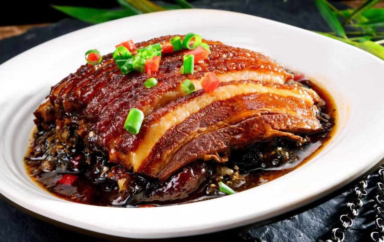 梅菜扣肉是一道经典的中华传统名菜，以其浓郁的香气、酥烂的肉质和鲜美的梅菜香味，深