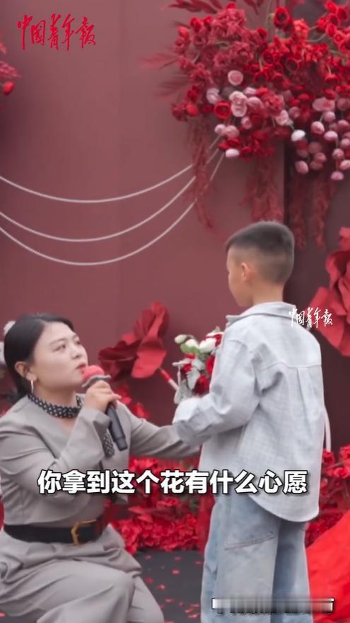 “火上央视了！”婚礼现场，一男孩抢到了姐姐扔的手捧花，主持人问他的心愿是什么，小