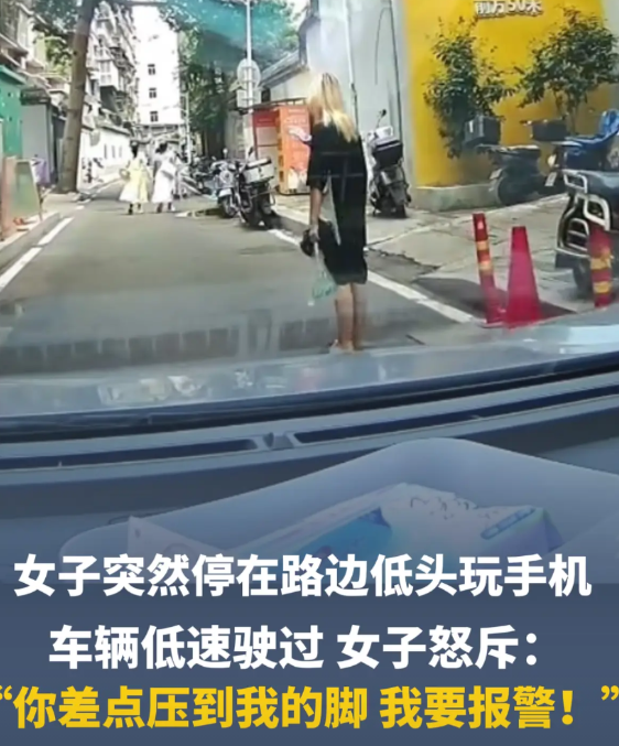 无理取闹！福建福州，一女子站在路中间玩手机，身后车子也没按喇叭，低速从旁边驶过，