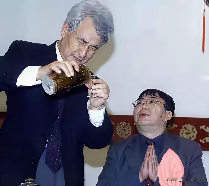 给聂卫平先生倒酒的这个人是谁？他手里拿的这瓶酒，感觉是一瓶陈年老酒，很有历史沧桑