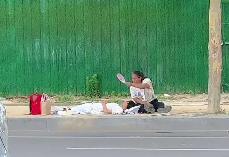 高考首日中午看到那一幕破防了。一位母亲坐在地上，拿着扇子不停地给躺地上睡觉的儿子