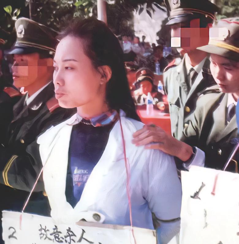 这张照片拍摄于1995年，照片中的女人名叫荣丰波，她胸前的牌子上写着“故意杀人”