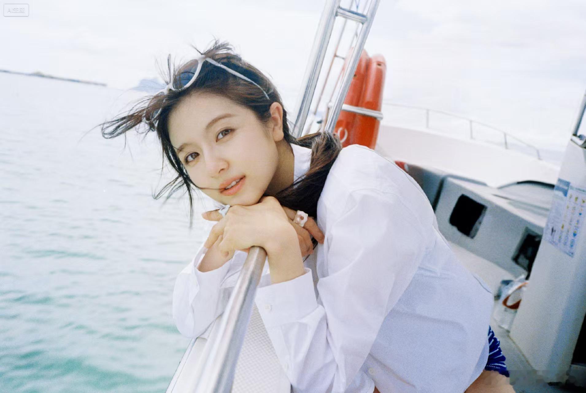李兰迪条纹泳装落日余晖铺满海面，蓝白条纹和海景相映成趣，松垮白衬衫随性披在肩头