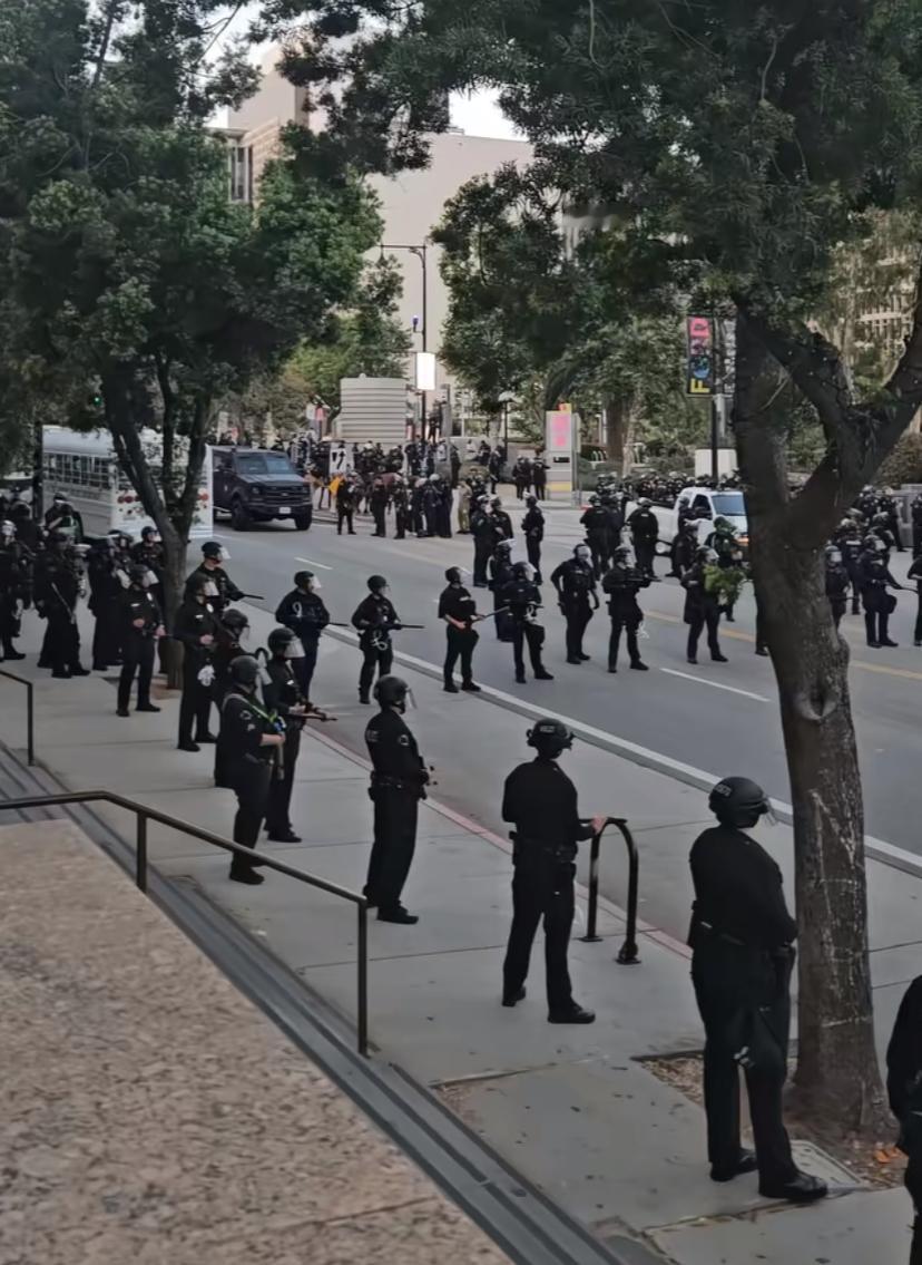 坐标洛杉矶，二三十位“冲动分子”被全副武装的大兵包围，里边有一群戴绿帽人群很淡定