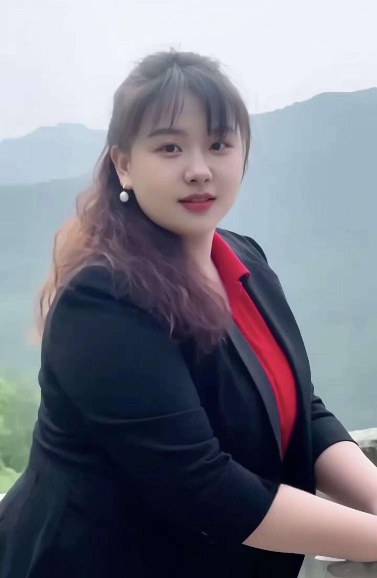 憨厚的媳妇媳妇生来性格憨，红衫黑褂笑开颜。青山作伴添生气，福气满满映远山。