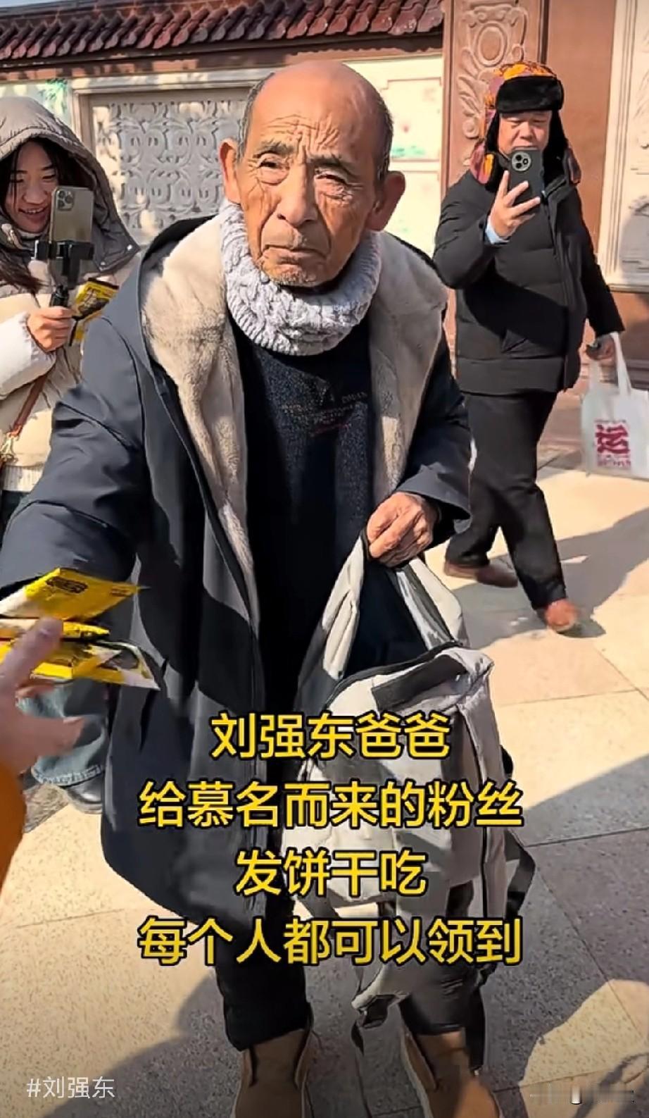 刘强东爸爸正在给慕名而来的粉丝发饼干，每个人都有。看着他老人家好疲惫的样子，