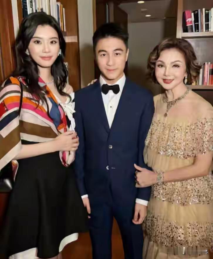 图一和何猷君夫妇合影的女子虽然年纪有点大，但贵妇气质让她一看就是富婆一枚。她还和