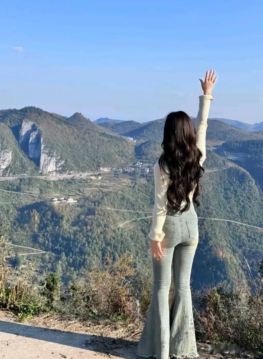 一个人站在山顶，眺望远方。